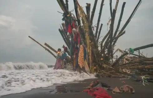 Suasana pesisir dengan manusia, kayu, dan deburan ombak menyiratkan keseharian serta kenangan sederhana. (fotografer: Rafael Krisna Putra Yuniantono | Lokasi: Pantai Pancer, Jember)