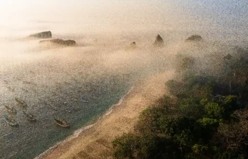 Kabut menyelimuti kawasan pesisir Tanjung Papuma dan perahu-perahu nelayan, menghadirkan suasana alam yang tenang. (fotografer: Prianto Puji Anggriawan | Lokasi: Tanjung Papuma, Jember)